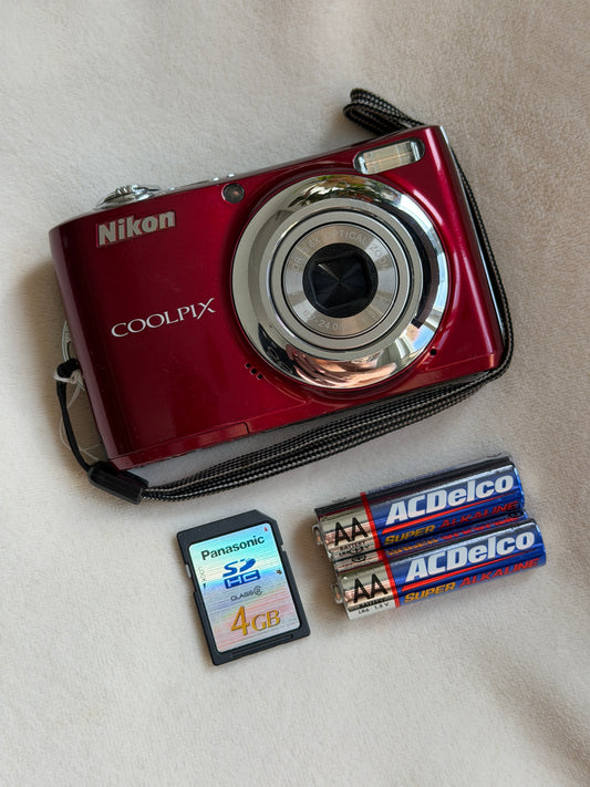 Nikon Coolpix L22 digital camera in red with batteries and memory card laid flat